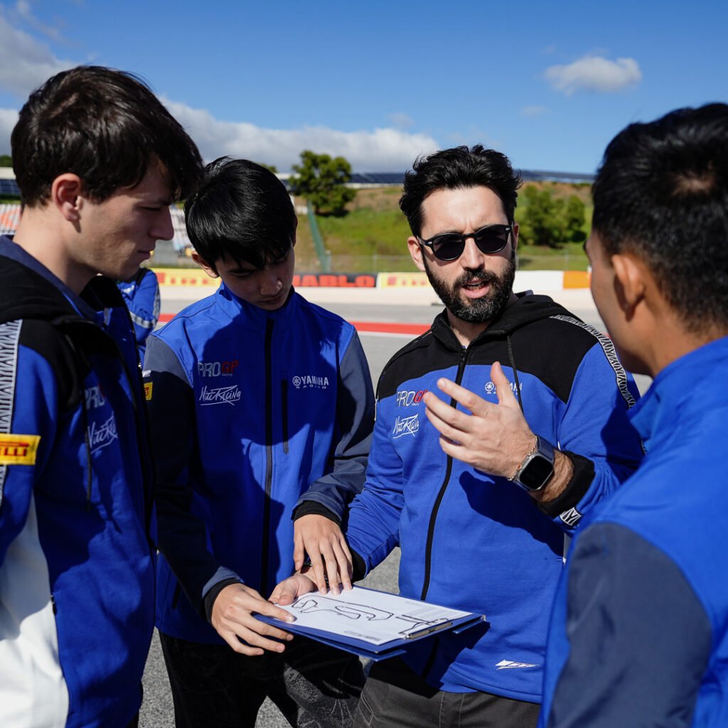 A NitiRacing mentor coaching a young rider trackside